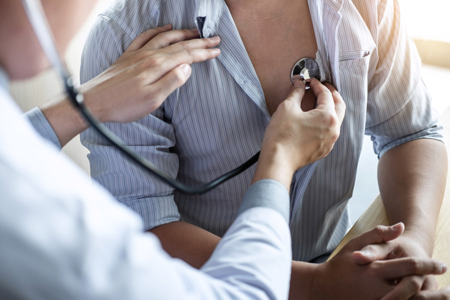 Doctor using a stethoscope to listen to a man's chest during a Cardiovascular Health checkup, offering services like low testosterone treatment, weight management, preventative care, chronic condition management, concierge healthcare, and facial and body scans at Men's Only Medical in West Palm Beach and Palm Beach.