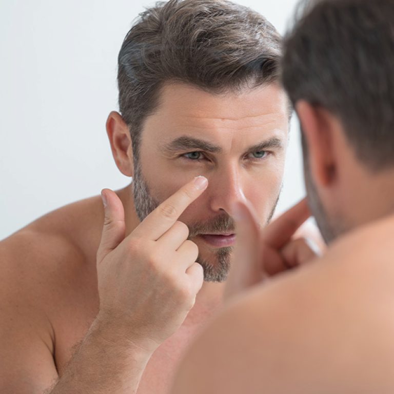 Man applying an Anti-Aging skin treatment to look younger during a consultation for facial and body scans, weight management, low testosterone treatment, and other men's health services at Men's Only Medical in West Palm Beach and Palm Beach.
